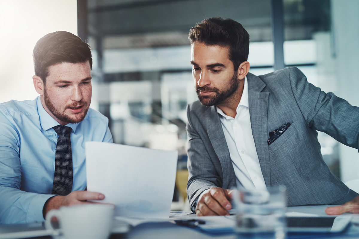 Shot of two young businessmen going through paperwork together in a modern office